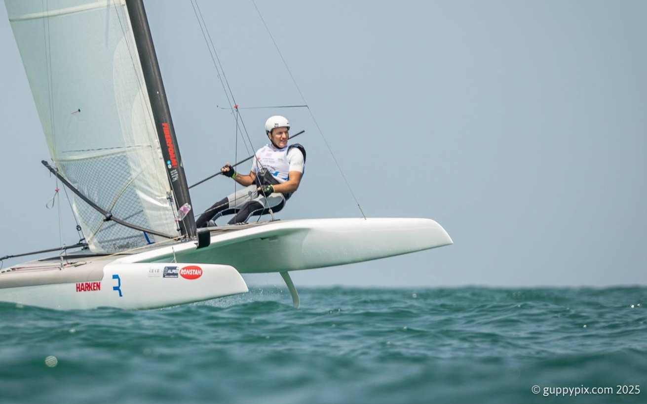A-Cat Europeans 2025. Day 2 finally saw some action on the water. Three races completed each fleet. Results at CSN web. Photo: Manolo Calavia by @guppypix